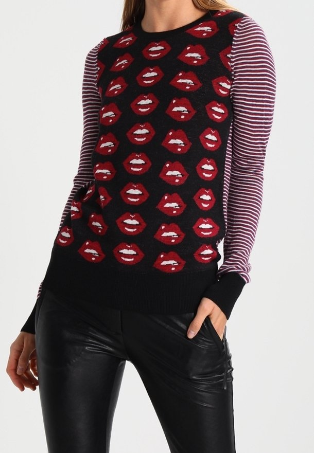 Schwarzer Pullover mit Muster roter Lippen auf der Vorderseite; gestreifte Ärmel in verschiedenen Violett- und Weißtönen; figurbetonter Stil, gerippte Bündchen.