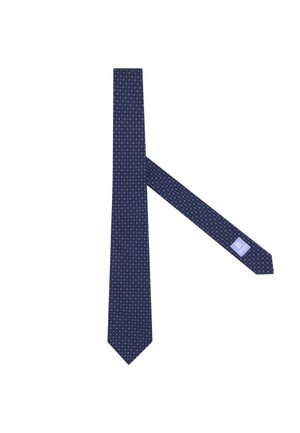 Krawat w kolorze granatowym z drobnym, białym geometrycznym wzorem oraz widoczną metką marki na wąskim końcu.