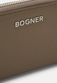 Brown leather wallet with textured surface and silver logo "BOGNER" stitched on the front. Features a contrasting zipper closure.