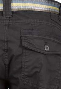 Zwarte cargobroek met een zijzak en een knoopdetail. De stof is soepel met een lichte glans en een textuurband in meerdere kleuren.