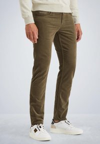 Oliwkowe spodnie w prążek o slim fit, z detalami stębnowania po bokach, pięcioma kieszeniami i naszywką z logo w pasie, połączone z białymi trampkami.