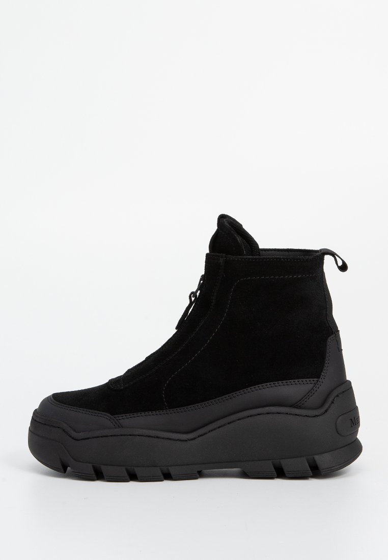 Schwarze Wildleder- und Gummihigh-top-Sneaker mit dickem, gerilltem Sohlenprofil und Reißverschlussverschluss auf weißem Hintergrund.