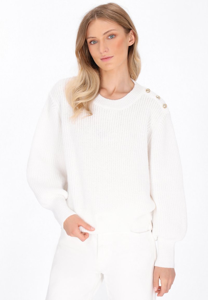 Weißer Strickpullover mit Rundhalsausschnitt, gerippten Bündchen und dekorativen goldenen Knöpfen auf der Schulter. Weiche Textur und lockere Passform.