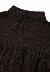 Leopardi-kuosiset pusero tumman violetissa ja mustassa. Ominaisuuksiin kuuluu korkea kaulus, kaksi nappia takana ja kerroksellinen rakenne vyötäröllä.