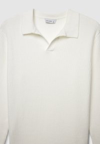 Polo bianco a maniche lunghe con tessuto morbido e strutturato, caratterizzato da un colletto classico e una mezza placca. Etichetta del marchio visibile.