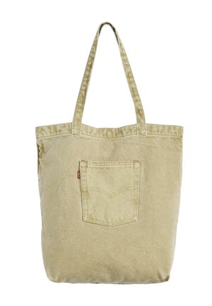 Beżowa torba na ramię z płótna, z dwoma uchwytami i małą przednią kieszenią, ozdobiona przeszytym wzorem i czerwoną metką.