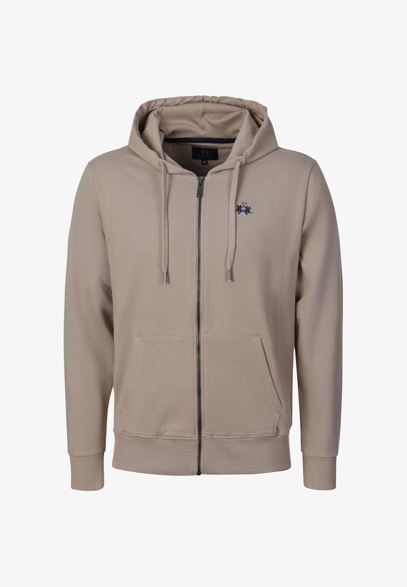 Beige hoodie met volledige ritssluiting, voorzakken, trekkoorden in de capuchon, geribde manchetten en zoom, en een klein donkerblauw geborduurd logo op de linkerborst.