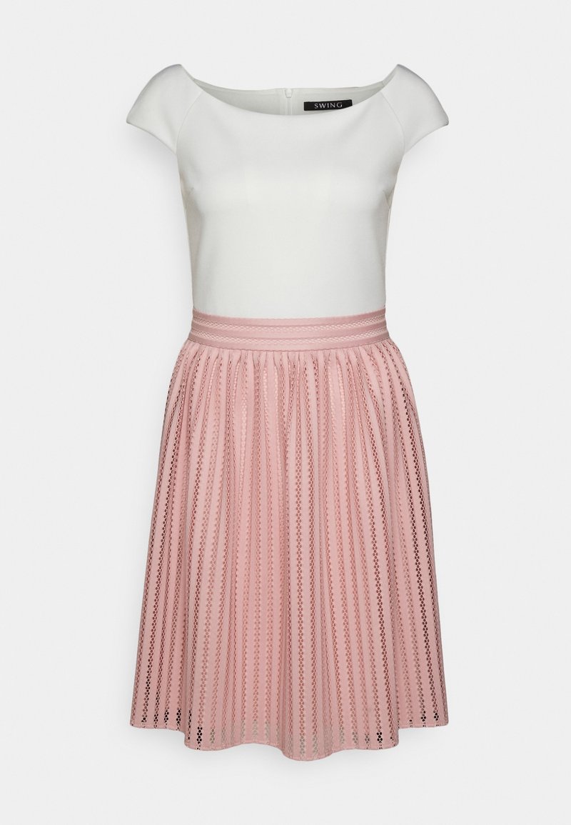 Haut blanc ajusté à manches courtes avec un col bateau, associé à une jupe plissée rose taille haute avec des motifs verticaux.