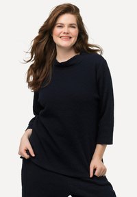 Top blu navy, strutturato, con collo a cascata e maniche tre quarti. Presenta un motivo sottile e una vestibilità comoda, abbinato a pantaloni coordinati.