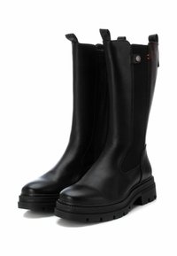 Stivali ankle in pelle nera con pannelli laterali elasticizzati, punta rotonda e suola in gomma spessa con tasselli di trazione per stabilità.
