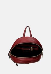 Sac à dos en cuir rouge avec une finition texturée, doté d'une fermeture éclair et de poches intérieures. Le design comprend une poignée et des bretelles réglables.