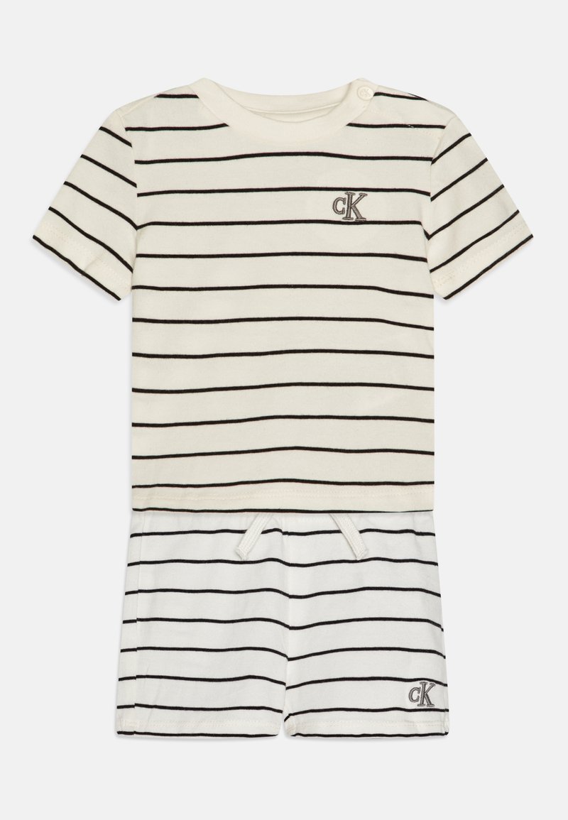 Striped cotton romper in cream and black. Short sleeves, round neck, with a decorative logo in the center. Adjustable waist with drawstring.