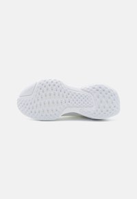 Semelle de chaussure de sport blanche en caoutchouc texturé, avec un motif en diamant pour l'adhérence et un design de semelle intermédiaire lisse et rembourrée.