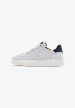Sneaker in pelle bianca con punta arrotondata, pannelli testurizzati e accentuazione in suede blu sul tallone. Presenta lacci bianchi piatti e una spessa suola in gomma.
