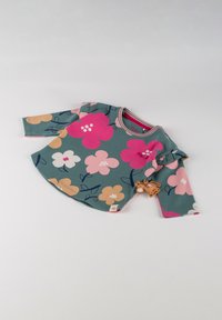 Langärmliges Oberteil mit floralem Muster in Türkis, geschmückt mit rosa, orangen und weißen Blumen. Rüschendetails an den Ärmeln und ein kleiner Tieranhänger angebracht.