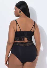 Černý krajkový bralet a set kalhotek s vysokým pasem, který se vyznačuje jemnými krajkovými detaily a nastavitelnými ramínky, s přiléhavým střihem.