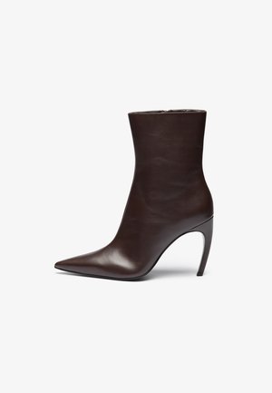 Botte de cheville en cuir marron avec un bout pointu, une silhouette élancée et un talon aiguille haut. Présente une texture lisse et un design minimaliste.