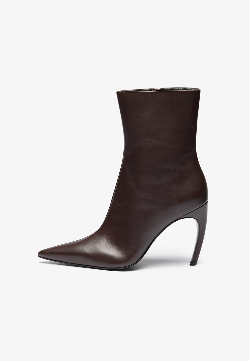 Brown leather ankle boot with a pointed toe, slim silhouette, and a high stiletto heel. Features a smooth texture and minimalistic design.