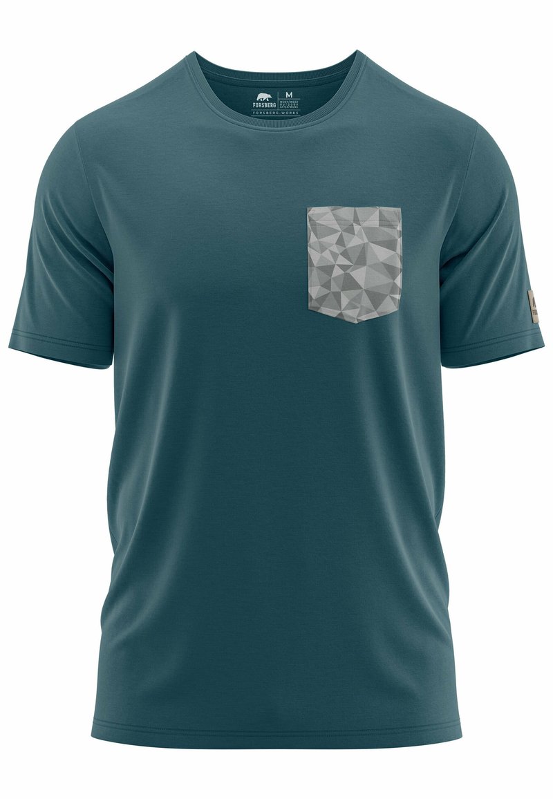 Camiseta de manga corta color teal, hecha de una tela suave, presenta un bolsillo en patrón geométrico gris en el lado izquierdo del pecho. Cuello redondo con una etiqueta.