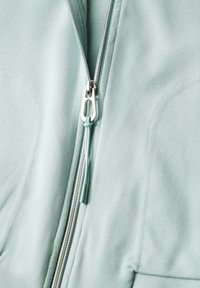 Hellblaues Zip-Hoodie mit silverfarbener Reißverschluss, das eine glatte Textur und subtile Nähte aufweist. Der Reißverschluss zieht entspricht dem blauen Farbton.