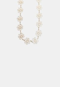 Collier doré composé de formes de fleurs entrelacées, chacune ayant des centres ouverts et des pétales arrondis, créant un design délicat et patterned.
