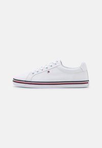 Sneaker bianco in tela con punta tonda, chiusura con lacci sul davanti e lati testurizzati. Presenta una striscia rossa e blu sulla suola e un logo sul lato.