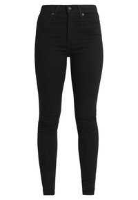 Jeans skinny negros de denim, con cintura alta, presillas para cinturón, diseño de cinco bolsillos y una textura suave y mate.
