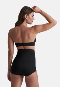 Czarny biustonosz bikini typu bandeau z zapięciem z tyłu, połączony z wysokim czarnym dołem, wykonanym z gładkiego, elastycznego materiału i z minimalnymi szwami.