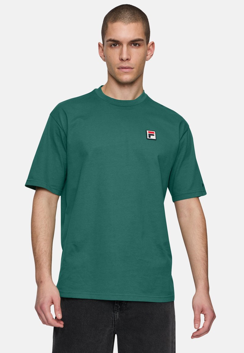 Maglietta di cotone verde con scollatura rotonda, maniche corte e un piccolo logo ricamato in un quadrato sul lato sinistro del petto. Design semplice.