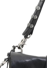Czarna skórzana torba o fakturowanym wykończeniu. Posiada klamrę z srebrnym wykończeniem oraz pasek ozdobiony metalowymi guzikami.