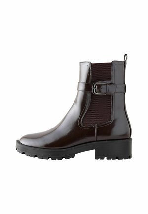 Bottine marron foncé brillante avec panneau élastique sur le côté, bride réglable avec boucle, languette de traction et semelle noire épaisse à crampons.