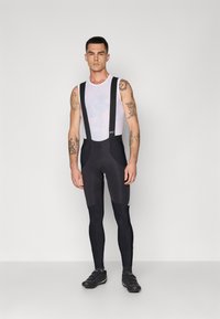 Cuissard de vélo noir avec bretelles ajustables, partie supérieure en mesh et siège rembourré. Comprend un tissu lissant et des coutures durables.