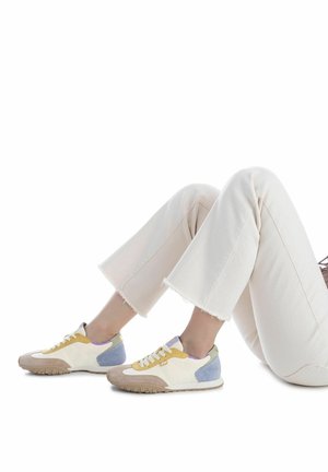 Baskets présentant un mélange de panneaux blancs, jaunes, lavande, verts et bleu clair avec une semelle texturée beige et des lacets blancs.