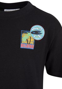 Black cotton t-shirt with a crew neckline featuring two graphic patches: a globe with palm trees and a circular logo with "KARL KANI MUSIC 1989."