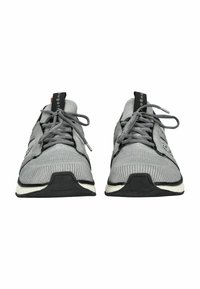 Scarpe da ginnastica grigie con una tomaia in mesh, design con lacci, dettagli testurizzati e una suola nera con un accento bianco.