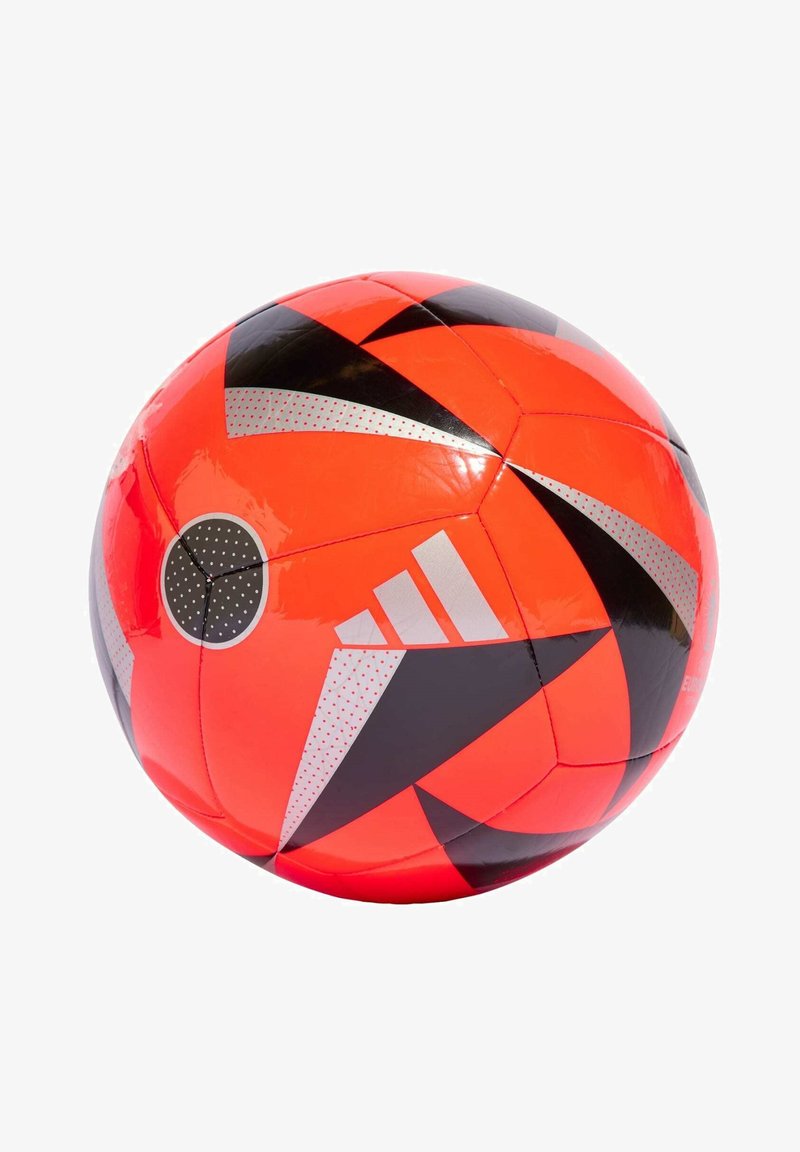 Pallone da calcio rosso con motivi geometrici neri e argentati. Presenta una superficie testurizzata e una macchia circolare nera con puntini bianchi.