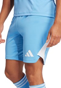 Lichtblauwe sportshorts van soepel materiaal, met witte Adidas-branding en een mesh inzet aan de zijkant voor ademend vermogen.