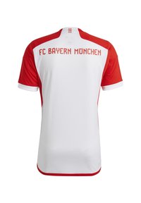 Punainen ja valkoinen FC Bayern Münchenin urheilupaita, jossa on joukkueen nimi paksulla punaisella fontilla selkäpuolella. Lyhyet hihat, pyöreä kaulus.
