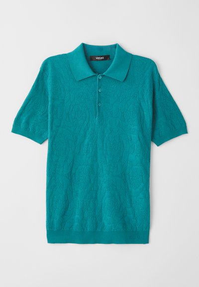 Tyrkysové polo tričko s textúrovaným kvetinovým vzorom, krátkymi rukávmi a golierom. Má trojité zapínanie na gombíky a rebrované manžety a lem.