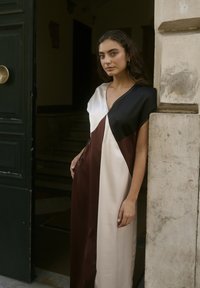 Satin obleka s color-block dizajnom, ki vključuje črne, kremne in burgundske panele; V-izrez in ohlapen kroj, s kratkimi rokavi.