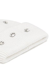 Cappello lavorato a maglia bianco con texture a coste, decorato con strass trasparenti sparsi. Il bordo ripiegato aggiunge profondità al design.