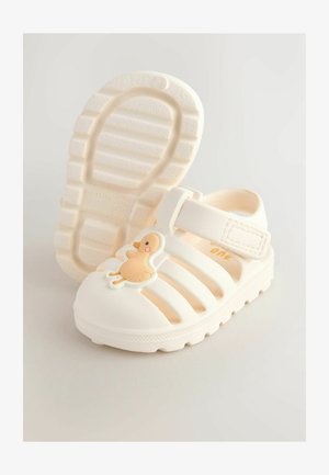 Biele gumové sandále s ventilačným dizajnom, na prednej strane s aplikáciou káčatka a suchým zipsom pre pevné uchytenie. Textúrovaná podrážka.