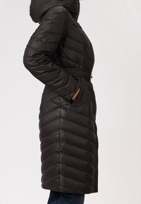 Lungo piumino nero con cappuccio, caratterizzato da un design trapuntato e una vita con cintura, tasche laterali e una texture liscia e lucida.