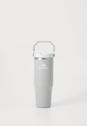 Kõrge heleda halli Stanley isoleeritud kruus valge kaanega ja külge kinnitatud nurga all oleva käepidemega, seisab püsti valgel pinnal.