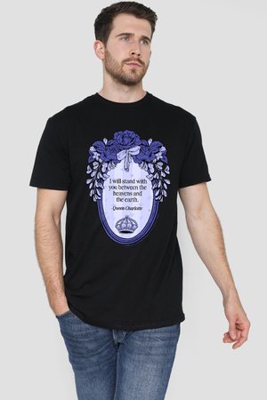 Man wearing black t-shirt with purple floral frame, ribbon, crown graphic, and text saying "I will stand with you between the heavens and the earth."