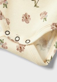 Cremfarbener, gerippter Bodysuit mit kleinen floralen Mustern in Rosa und Grün, ausgestattet mit Druckknöpfen am Boden für einfachen Zugang.