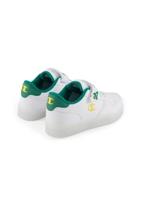 Weiße Sneaker mit grünen Akzenten, glattes Leder, runde Zehenpartie, Schnürverschluss und ein gelbes Logo an Ferse und Zunge.