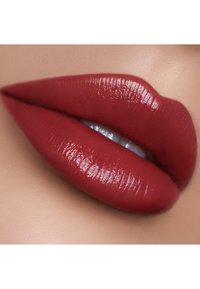 Tiefrote matte Lippen mit einer glatten, leicht glänzenden Textur, die eine definierte Form und Konturen vor einem neutralen Hintergrund zeigen.