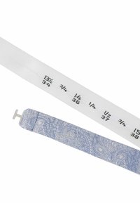 Weißes Stoffmaßband mit schwarzen Markierungen und einem blauen gemusterten Stoff mit einem silbernen Metallhaken an einem Ende.