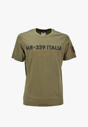 Maglietta khaki a maniche corte con la scritta "MB-339 ITALIA frecce tricolori" e stemma della bandiera italiana, oltre a una toppa sulla manica sinistra.